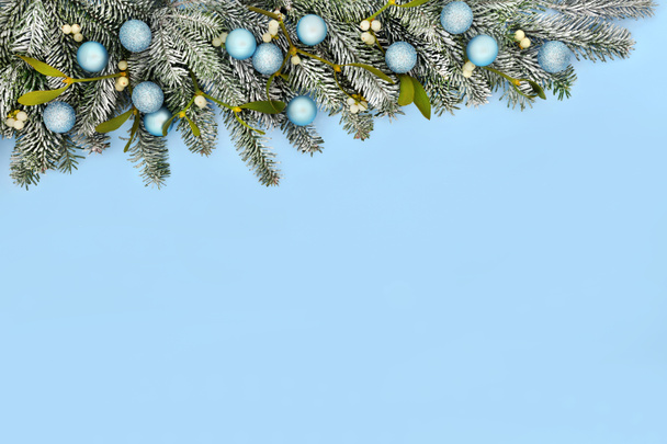 Navidad abeto nieve árbol de muérdago bauble borde de fondo en azul pastel. Composición de la naturaleza mínima para el invierno, Navidad y Año Nuevo temporada festiva. - Foto, imagen