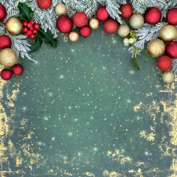 Christmas traditional old fashioned festive background border with snow covered fir, holly, red gold tree bauble decorations on grunge green. Xmas nature abstract design. - Photo, Image