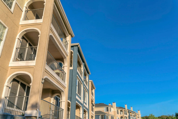 Austin, Texas Vue en angle bas d'un complexe d'appartements avec balcons. Bâtiment résidentiel extérieur avec murs beige, bleu et garnitures blanches. - Photo, image