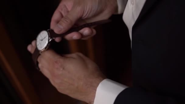 スーツの新郎は、革のストラップと時計に置きます。高品質のフルHD映像 - 映像、動画