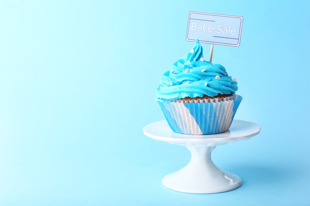 Delicious cupcake with inscription on blue background - Fotoğraf, Görsel