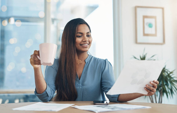 Lidar com negócios com total facilidade. uma jovem empresária bebendo café enquanto trabalhava em um escritório - Foto, Imagem
