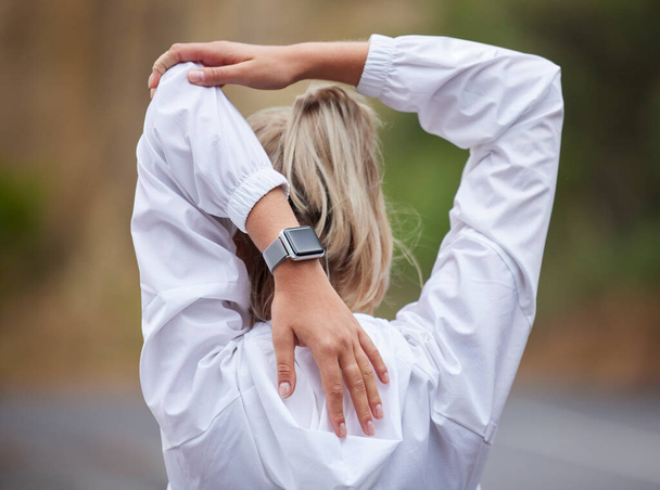 Fitness, warm up and woman stretching in the park before exercising, running and workout. Health, wellness and sports girl doing stretch for back and arm muscles before exercise, ready to run on road. - Foto, afbeelding