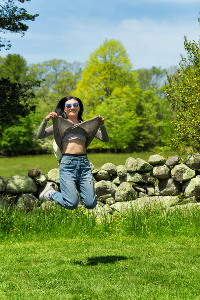 a chinese woman jumping flashing her bra outside in a park on martha's vineyard massachusetts. - Photo, Image