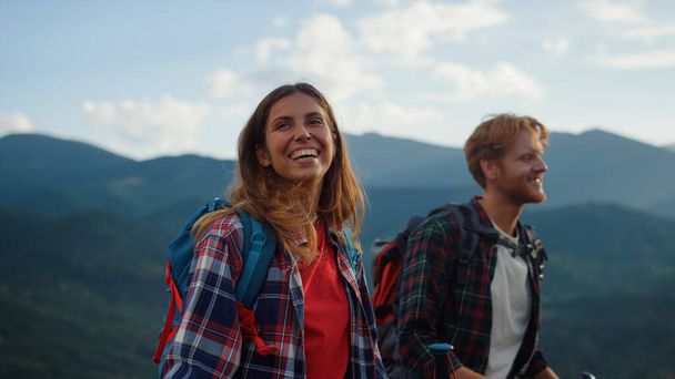 Laughing couple trekking mountains hike. Close up two tourists smile together outside on family vacation. Joyful backpackers enjoy walk in summer nature. Wanderlust happiness relationship concept. - Photo, Image