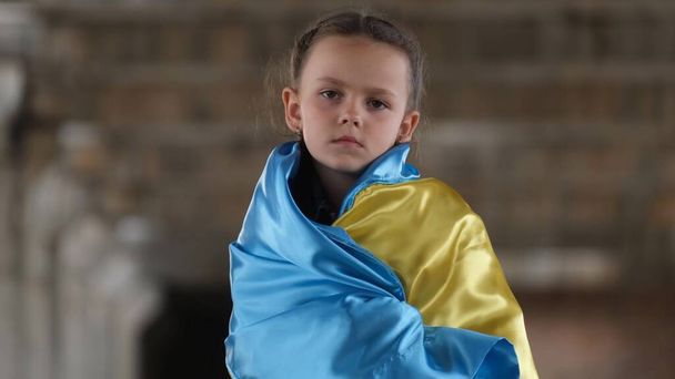 Ukrayna bayrağı taşıyan üzgün bir kızın portresi. Rusya 'nın saldırısına son verme talebi. Kriz, savaş, barış yok, yardım. Savaşın çocukları. Ukrayna ve Rusya arasındaki savaş - Fotoğraf, Görsel