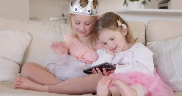 Смартфон, диван і принцеса діти дивитися відео, ігровий додаток або онлайн-сайт для дітей для домашнього навчання, свято веселощів або вечірки на день народження. Щасливі сестри на мобільному телефоні для фільму або фільму про фею
. - Кадри, відео