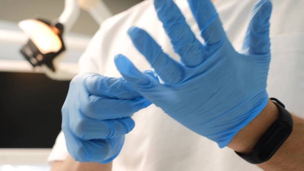 The doctor, assistant, anesthesiologist put on gloves before treatment, surgery. Surgical gloves. Dentists hand - Foto, immagini