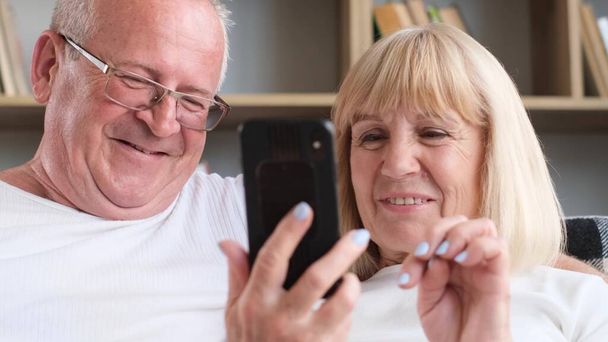 Close-up of the faces of a husband and wife searching the Internet. Happy and smiling elderly couple. - Foto, Imagem