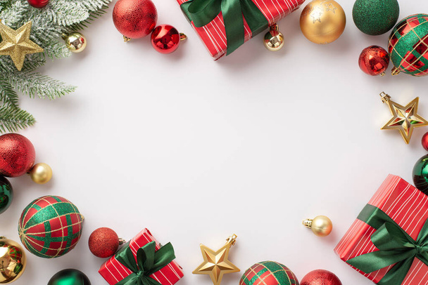 Χριστουγεννιάτικη ιδέα. Κορυφή φωτογραφία άποψη του κόκκινο πράσινο και χρυσό στολίδια αστέρι κουτιά δώρων στολίδια με τόξα και πεύκο υποκατάστημα σε απομονωμένο λευκό φόντο με copyspace στη μέση - Φωτογραφία, εικόνα