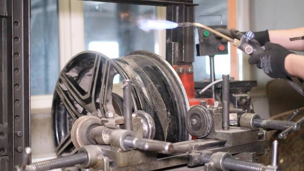 Automobilový mechanik přizpůsobí ráfky vozu svařovacímu stroji. Orientace ocelových disků. Autoservis - Fotografie, Obrázek