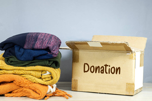 pahvilaatikko, jossa on käytetyt vaatteet sodan uhrien lahjoittamiseen, keräämiseen ja tukemiseen, ihmisten auttamiseen, hyväntekeväisyyteen - Valokuva, kuva