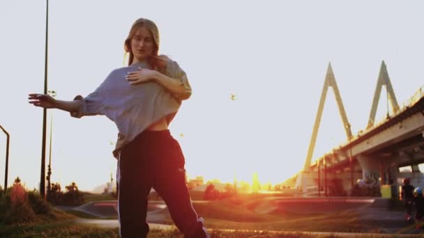 Skinny pretty woman with long light hair dancing at early sunset. Mid shot - Footage, Video