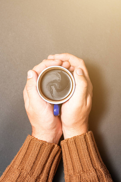 Mãos masculinas segurando café em um fundo escuro, uma xícara de café preto nas mãos. - Foto, Imagem