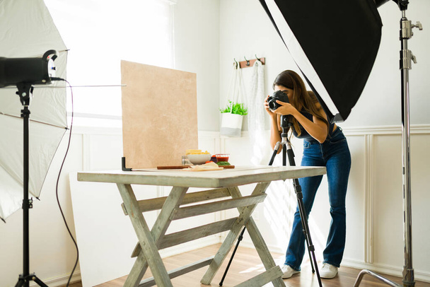 Hispanic female photographer doing a food photo shoot with professional equipment  - Fotografie, Obrázek