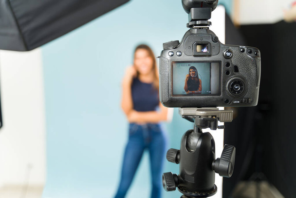 Zadní pohled na profesionální fotoaparát s obrazovkou zobrazující fotografie modelu pózujícího ve fotografickém studiu - Fotografie, Obrázek