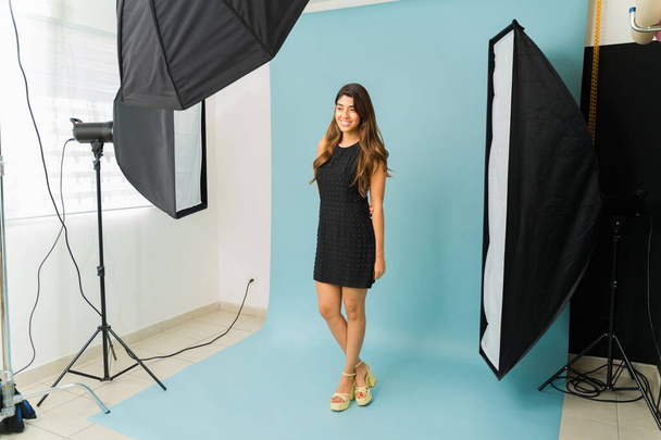 Houkutteleva latino nuori nainen malli poseeraa aikana muoti valokuva ampua muodollinen musta mekko studiossa  - Valokuva, kuva
