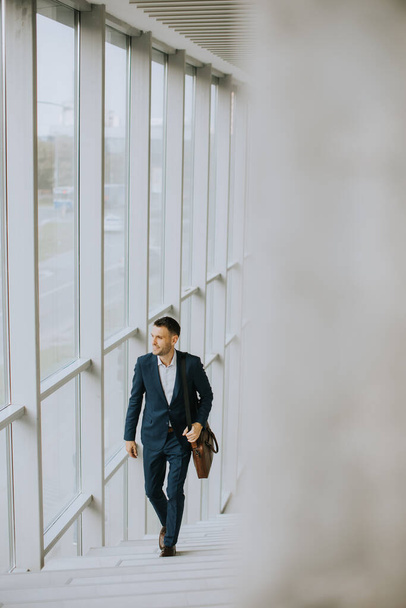 Handsome young business executive with briefcase going up the stairs - Fotoğraf, Görsel