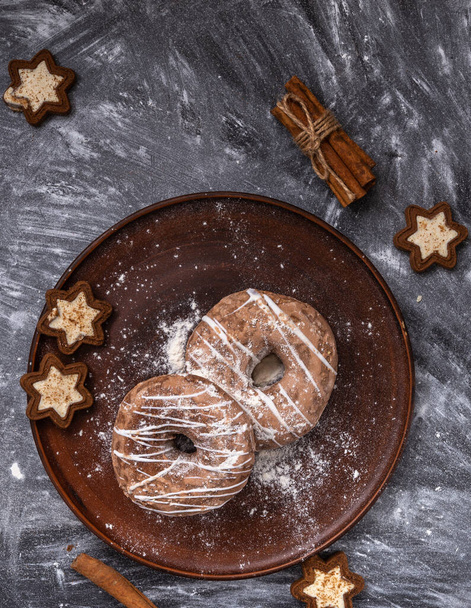 Homemade craft gingerbread cookies sprinkled with powdered sugar on a gray background. - Φωτογραφία, εικόνα