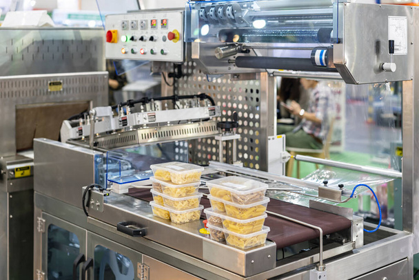 продукты питания в несколько пластиковых коробок помещены на автоматической пленки обертывания или защитной упаковочной машины для товаров или другого продукта и т.д. - Фото, изображение