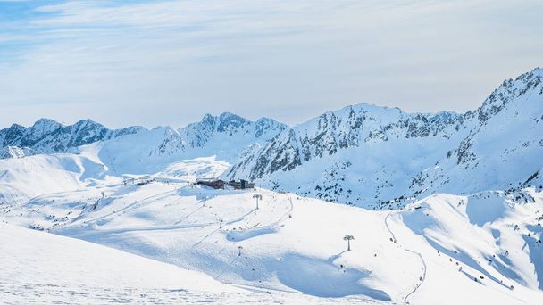 Skilift-Langlaufzentrum auf einem schneebedeckten Gipfel in wunderschöner Winterlandschaft mit Bergkette im Hintergrund, Andorra, El Tarter, Pyrenäen - Foto, Bild
