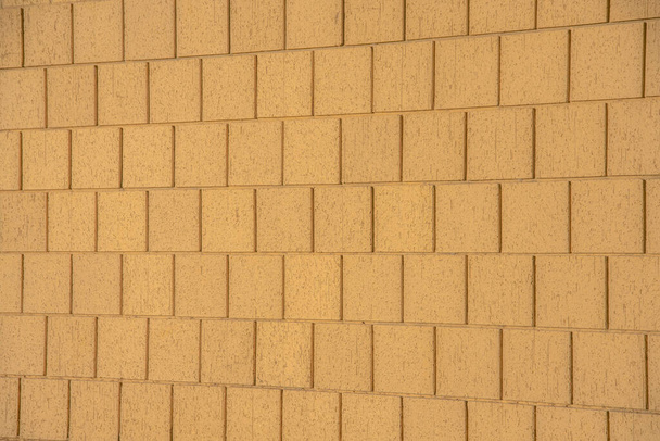 Primo piano di blocchi di muro di calcestruzzo color sabbia di un edificio. Esterno di un edificio con blocchi di cemento con modello di legame funzionante. - Foto, immagini