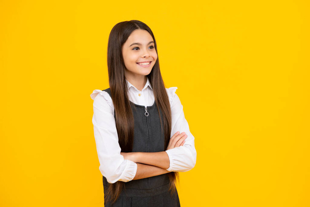 Teenager kid crossed arms with confidence isolated on yellow. Confident teen child girl crossed hands. Happy girl face, positive and smiling emotions - Photo, Image