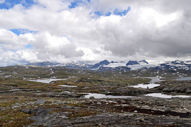 Sognefjell, Jotunheim, Norveç. Doğal parktaki karlı kayalık arazi. Karla kaplı kayalar, dağlar ve buzlu göller.. - Fotoğraf, Görsel