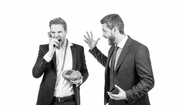 Professional man with smartphone look at angry businessman shouting in telephone receiver isolated on white, bad voice connection. - Photo, Image