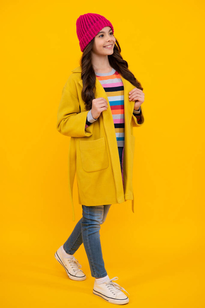 Full length photo of pretty teenager child girl wear casual clothes isolated on yellow background. Happy teenager, positive and smiling emotions of teen girl - Valokuva, kuva