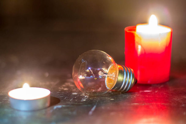 Glazen lamp tussen kaarsen. Blackout in Oekraïne als gevolg van oorlog - Foto, afbeelding