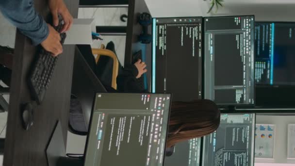 Pionowe wideo: Zróżnicowany zespół programistów baz danych analizujących kod w oknie terminala, pracujących ze skryptem html i sztuczną inteligencją. Inżynierowie systemu rozmawiają o interfejsie tworzenia aplikacji. - Materiał filmowy, wideo