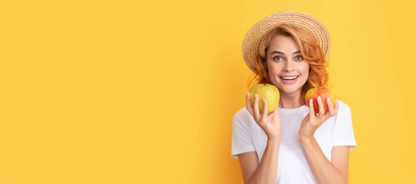 La chica del verano sostiene la manzana. alegre pelirroja en sombrero de paja mantenga manzana, vitamina. Retrato de cara aislada de mujer de belleza, pancarta con espacio de copia simulada - Foto, imagen