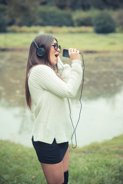 Jonge brunette vrouw luisteren muziek - Foto, afbeelding