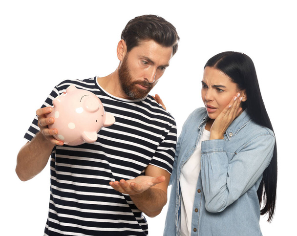 Couple with ceramic piggy bank on white background - Foto, afbeelding
