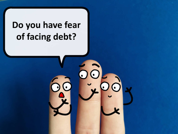 Tres dedos están decorados como tres personas. Están discutiendo sobre finanzas. Uno de ellos está preguntando a otros si tienen miedo de enfrentar la deuda. - Foto, imagen