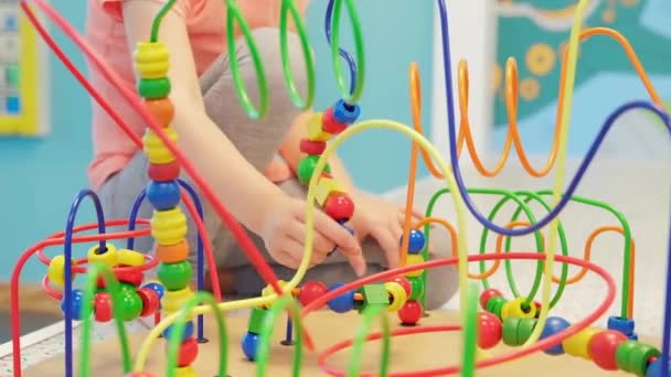 Kinder Hände spielen Holz Draht Labyrinth Lernspiel Spielzeug Kleinkind-Blöcke. Ein Spiel zur Entwicklung der Logik und Feinmotorik der Hände. Nahaufnahme. Selektiver Fokus - Filmmaterial, Video