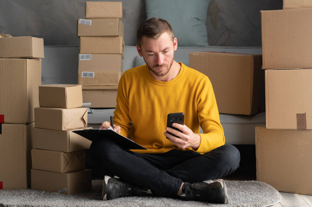 Starting small businesses SME owners man entrepreneurs working at home, box and check online orders to prepare to pack the boxes, sell to customers, sme business online concept. - Foto, afbeelding