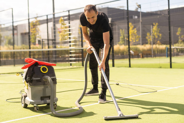 man with professional vacuum cleaner for the tennis court. - Fotografie, Obrázek