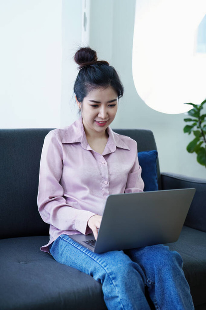 Portrait of a self-employed Asian woman using a computer at home. - Φωτογραφία, εικόνα
