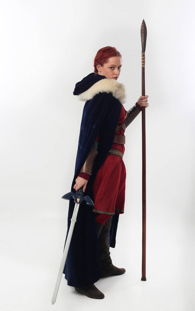 retrato de comprimento total de mulher bonita vestindo um traje guerreiro fantasia medieval vermelho com armadura de couro, segurando armas. De pé pose isolada no fundo do estúdio branco. - Foto, Imagem