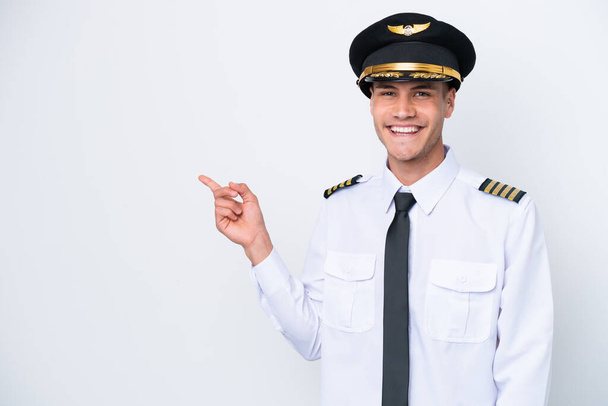 Flugzeug kaukasischen Piloten isoliert auf weißem Hintergrund zeigt mit dem Finger zur Seite - Foto, Bild