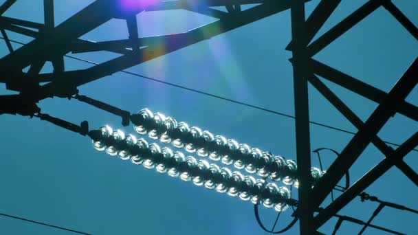 Stromleitungen mit Sonnenstrahlen am blauen Himmel. Hochspannungsumspannwerk. Stromkrise in der Welt. Grüne Energie in Stromleitungen. Selektiver weicher Fokus - Filmmaterial, Video