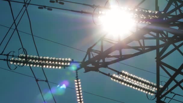 Stromleitungen mit Sonnenstrahlen am blauen Himmel. Hochspannungsumspannwerk. Stromkrise in der Welt. Grüne Energie in Stromleitungen. Selektiver weicher Fokus - Filmmaterial, Video