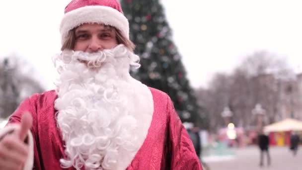 Χαρούμενος Άγιος Βασίλης δείχνει τον αντίχειρά του. Συναίσθημα ευτυχίας και χαράς, ατμόσφαιρα διακοπών. Καλή Χρονιά 2023 και Καλά Χριστούγεννα. Βίντεο 4k - Πλάνα, βίντεο
