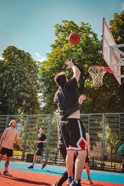 ウクライナのリヴィウ-2022年5月28日:男性は屋外で夏の晴れた日にバスケットボールをプレイ - 写真・画像