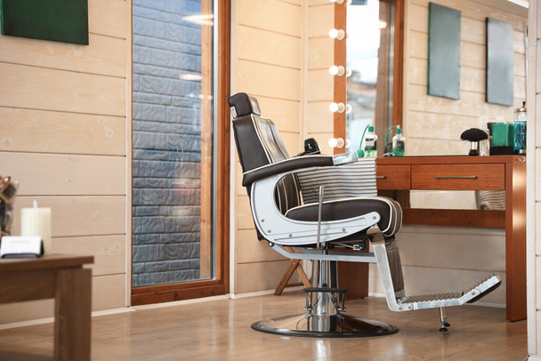 Stylish hairdresser's workplace with professional armchair in barbershop - Foto, Bild