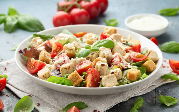 Vegetarian ceasar salad with meat free chicken pieces cherry tomatoes croutons and lettuce in white plate - Photo, image