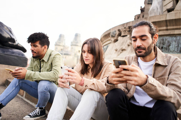 Individuele mensen chatten met de smartphone negeren elkaar met behulp van Mobile. Individuele vrienden Technologieverslaafden. Hoge kwaliteit foto - Foto, afbeelding