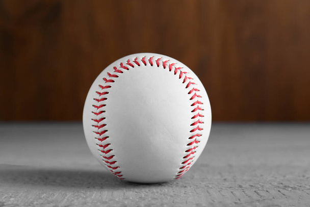 Baseball ball on grey wooden table, closeup. Sportive equipment - 写真・画像